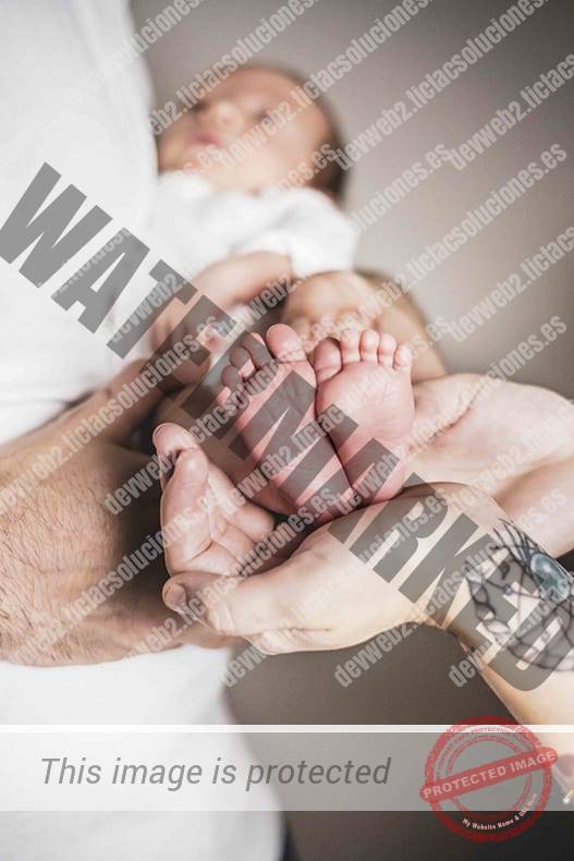 Fotografía de pies de Bebe sostenido por sus padres